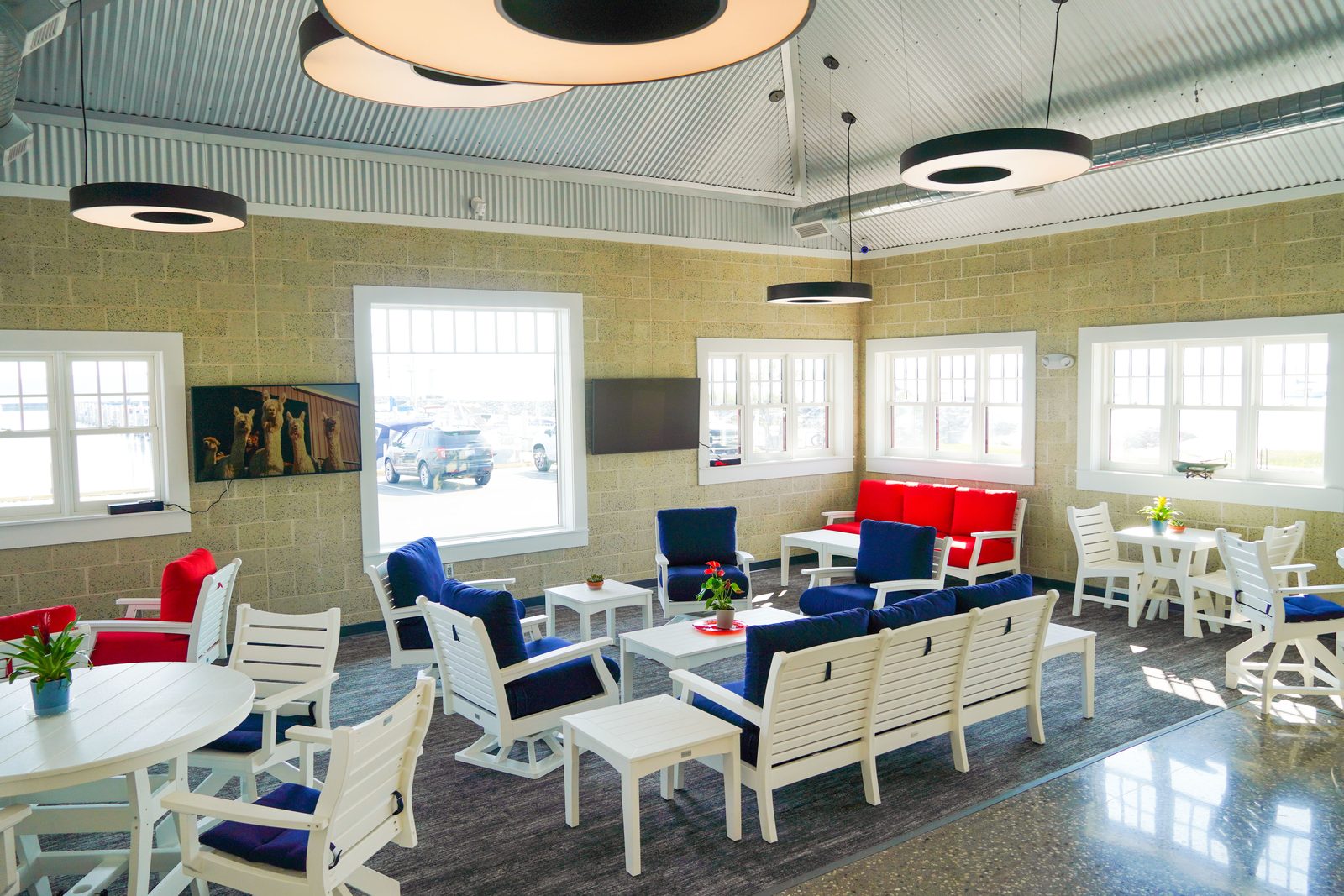 Seating area in the Captain's Lounge with navy and red cushioned chairs and harbor-view windows.