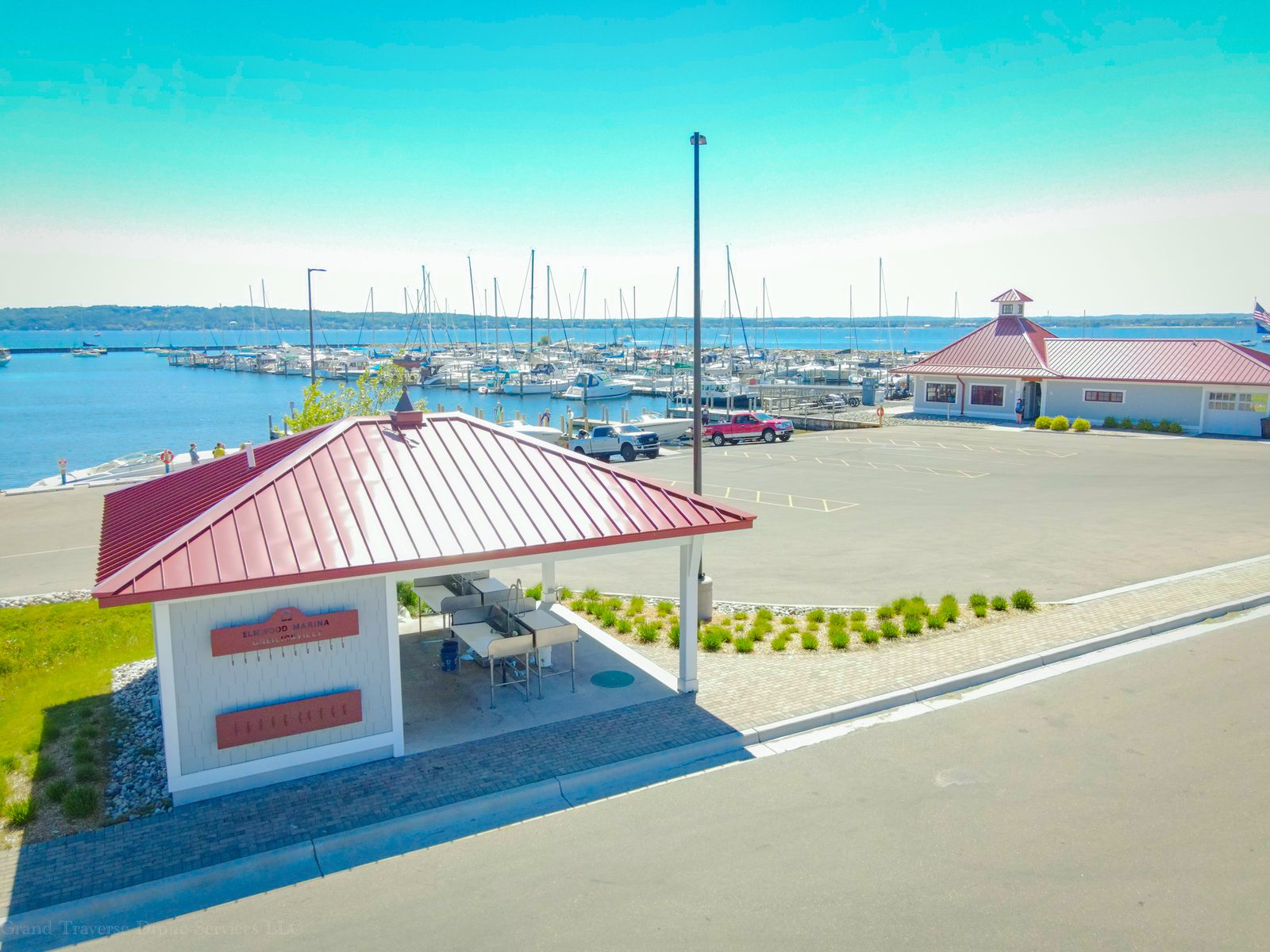 Aerial view of the covered fish-cleaning station beside the marina and harbor full of sailboats.