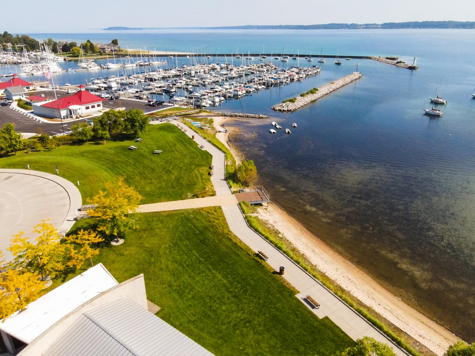 Aerial view of the marina, sandy beach, and grassy Greilickville waterfront park.