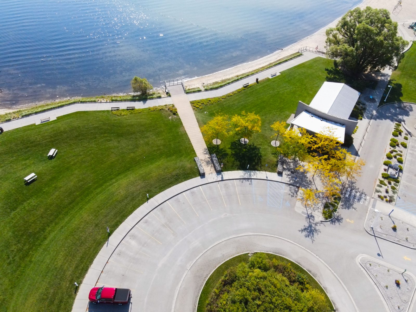 Aerial of the park turnaround, beach, and shoreline path beside the bay.