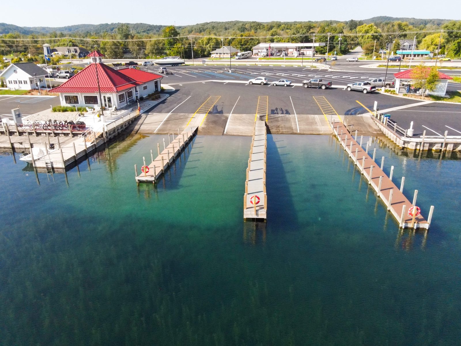 Launch ramp courtesy docks reaching out into clear green water.