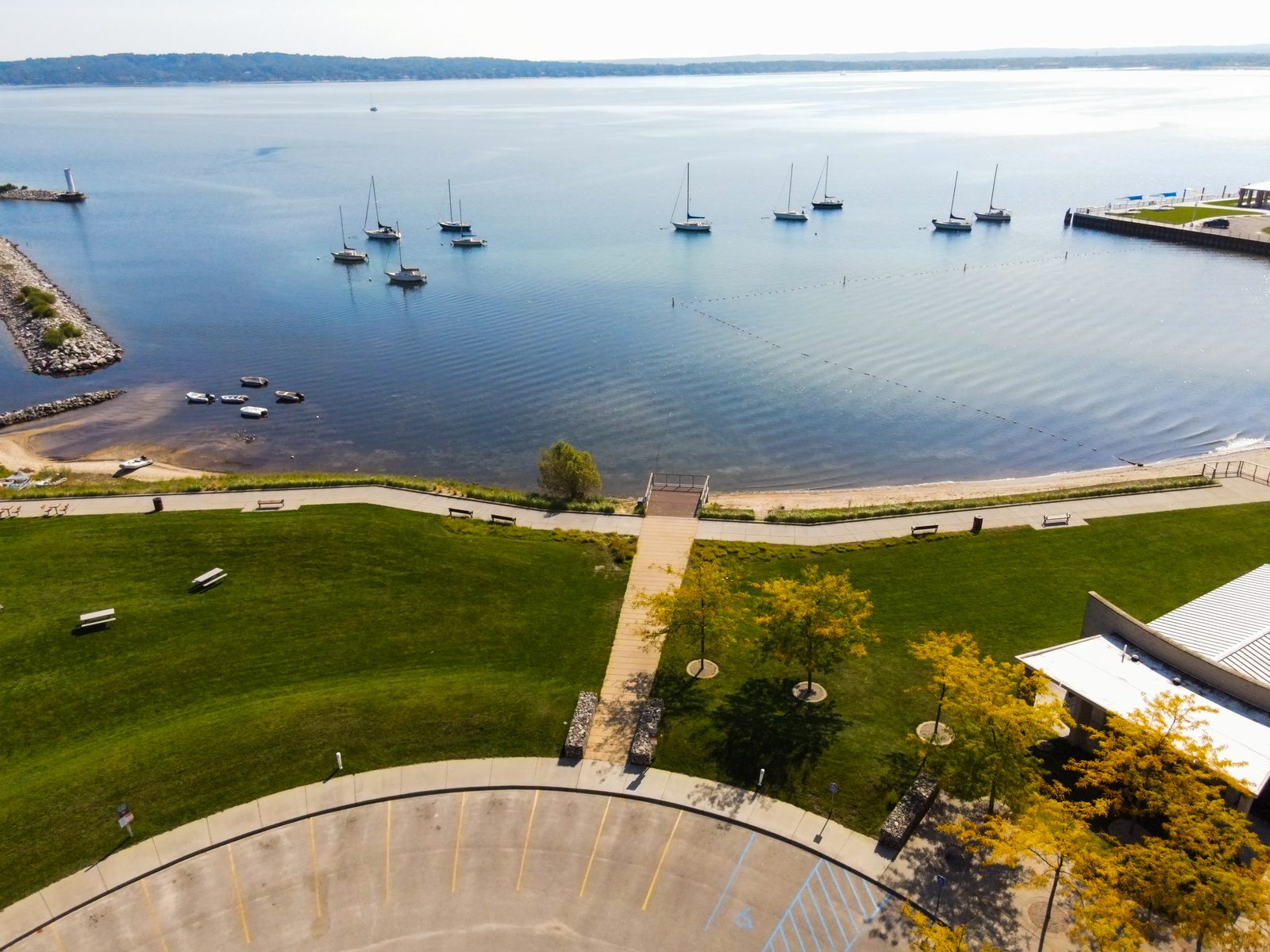 Sailboats moored off the sandy beach on a calm Grand Traverse Bay morning.